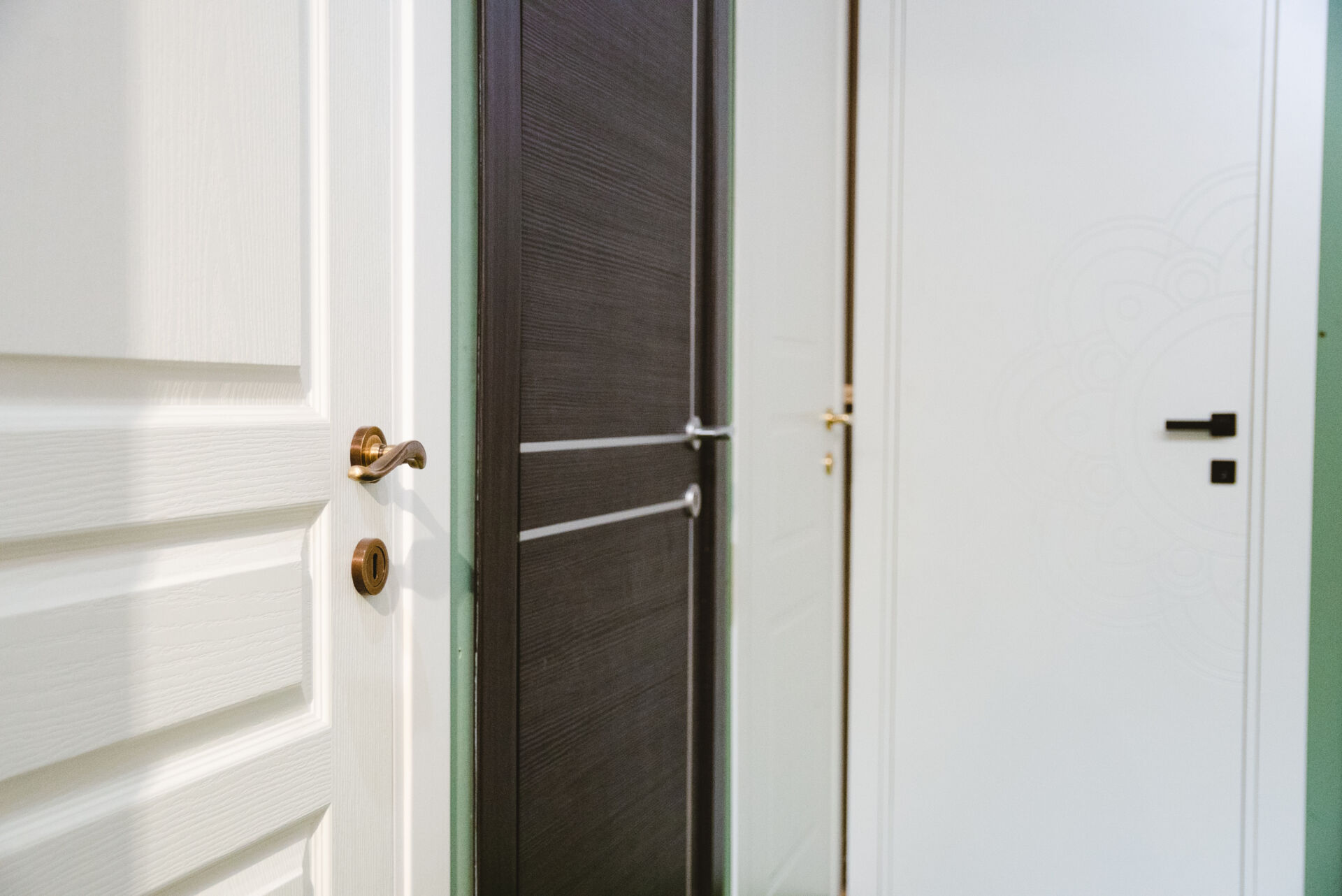 Porte interne: bianca a pannelli con maniglia bronzo, scura con inserti metallici, liscia decorata a mandala e leva nera